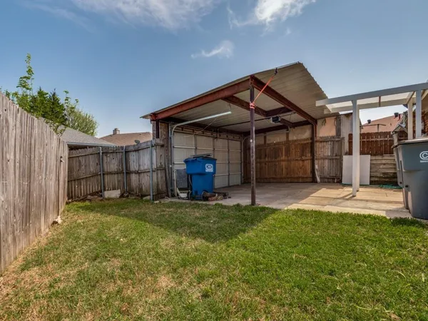 a view of a house with a small yard and wooden fence