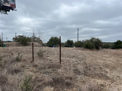 a view of a dry yard with wooden fence