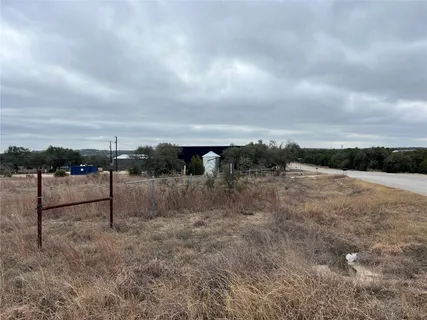 a view of a dry yard with wooden fence