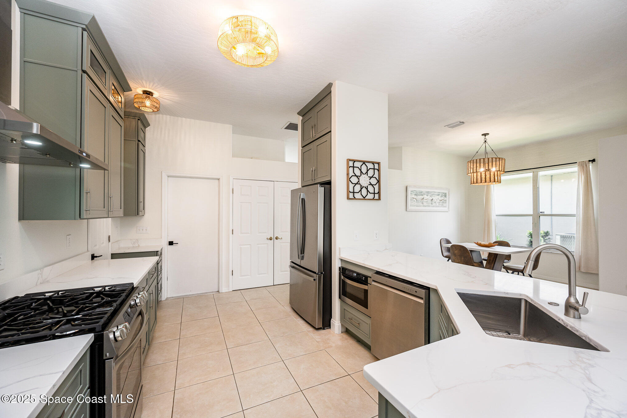 853 Villa Drive Melbourne, FL 32940 - Photo 22 of 26 a kitchen with granite countertop a refrigerator and a stove top oven