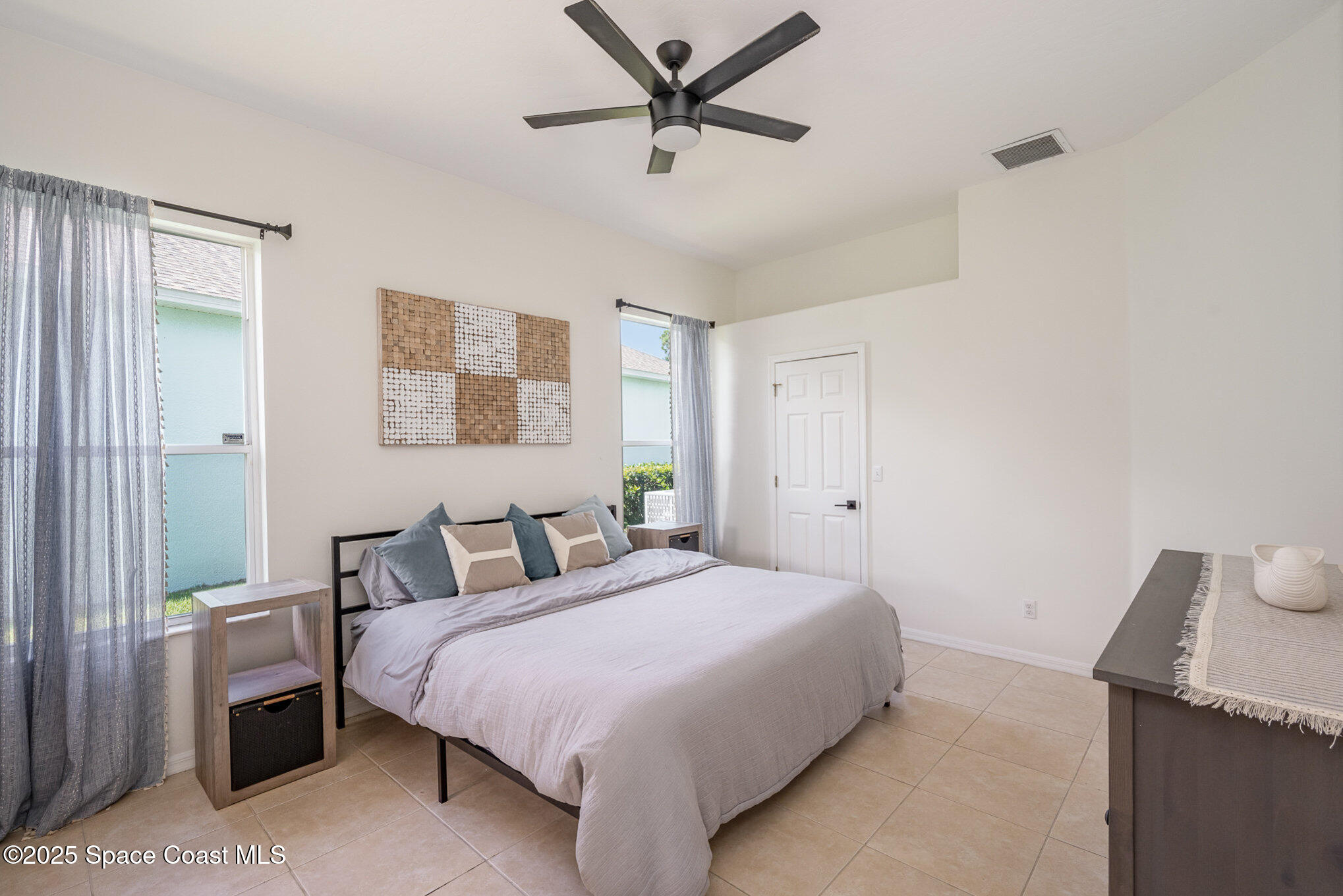 853 Villa Drive Melbourne, FL 32940 - Photo 7 of 26 a bedroom with a bed and a chandelier