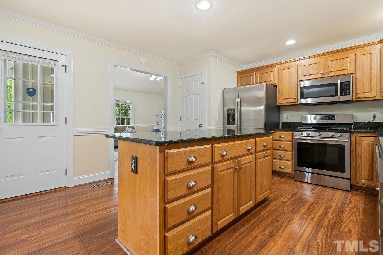 48 Eagle Pointe Lane Clayton, NC 27520 - Photo 7 of 21 a kitchen with stainless steel appliances granite countertop a stove a sink and a refrigerator