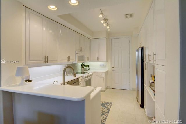a kitchen with kitchen island a sink stainless steel appliances and cabinets