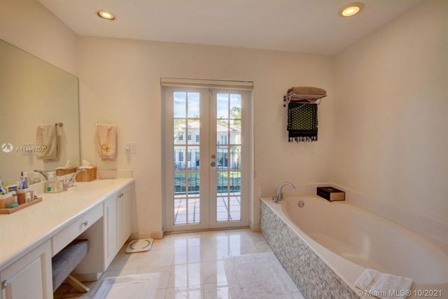 a bathroom with a bathtub a sink a mirror a window and a shower