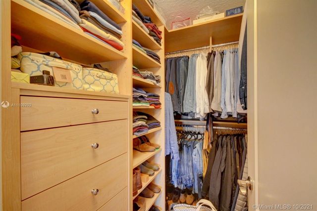 a view of walk in closet with clothes