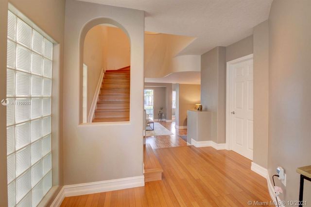 a view of a bedroom with wooden floor and windows