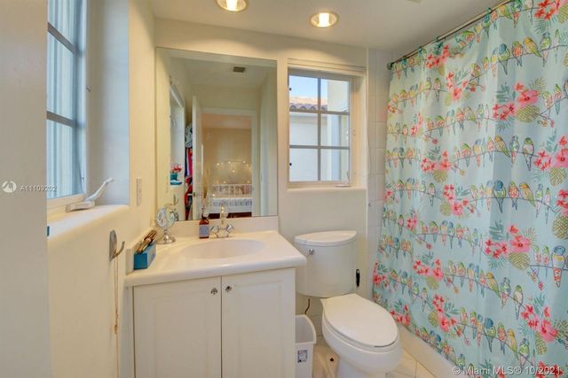 a bathroom with a sink a toilet and shower curtain