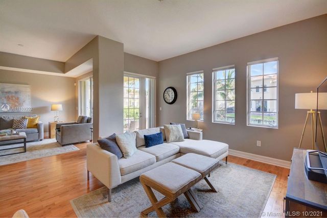 a living room with furniture and floor to ceiling windows