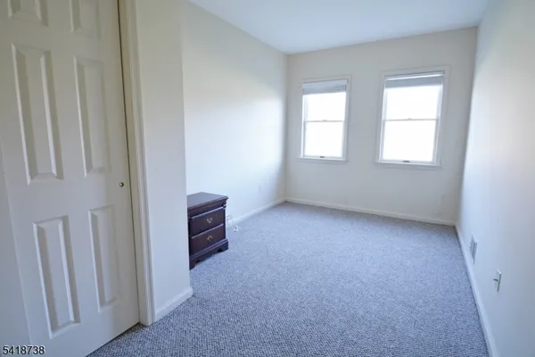 an empty room with windows and cabinet