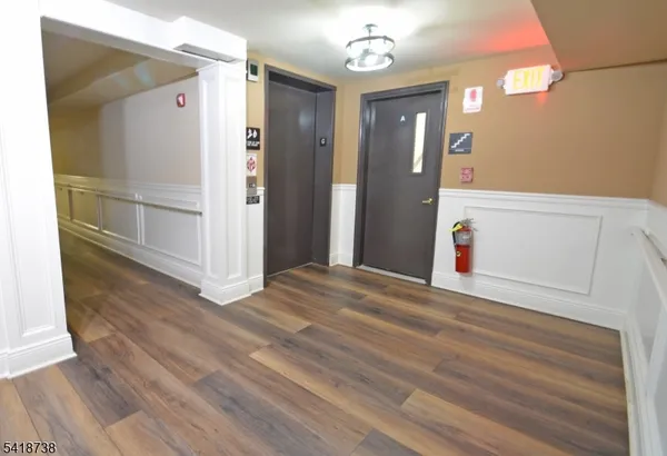 a view of a hallway with wooden floor and closet