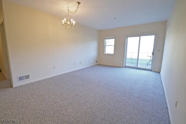 a view of a big room with windows and chandelier fan