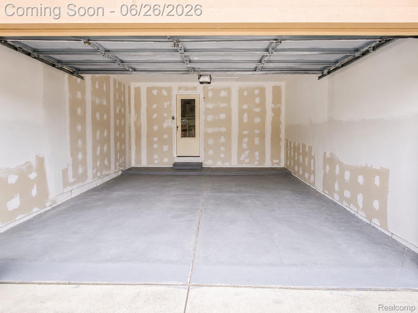 17014 Country Ridge Lane Macomb, MI 48044 - Photo 23 of 25 Spacious garage featuring a concrete floor, overhead lighting fixture, and an interior access door with a window