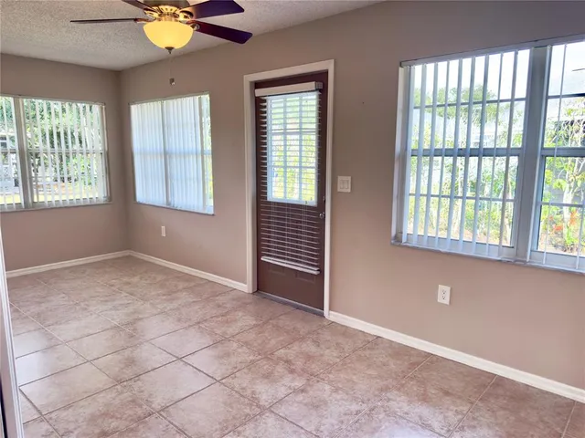 a view of a room with wooden floor and a ceiling fan