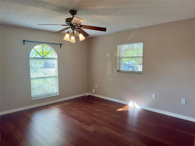a view of an empty room with wooden floor