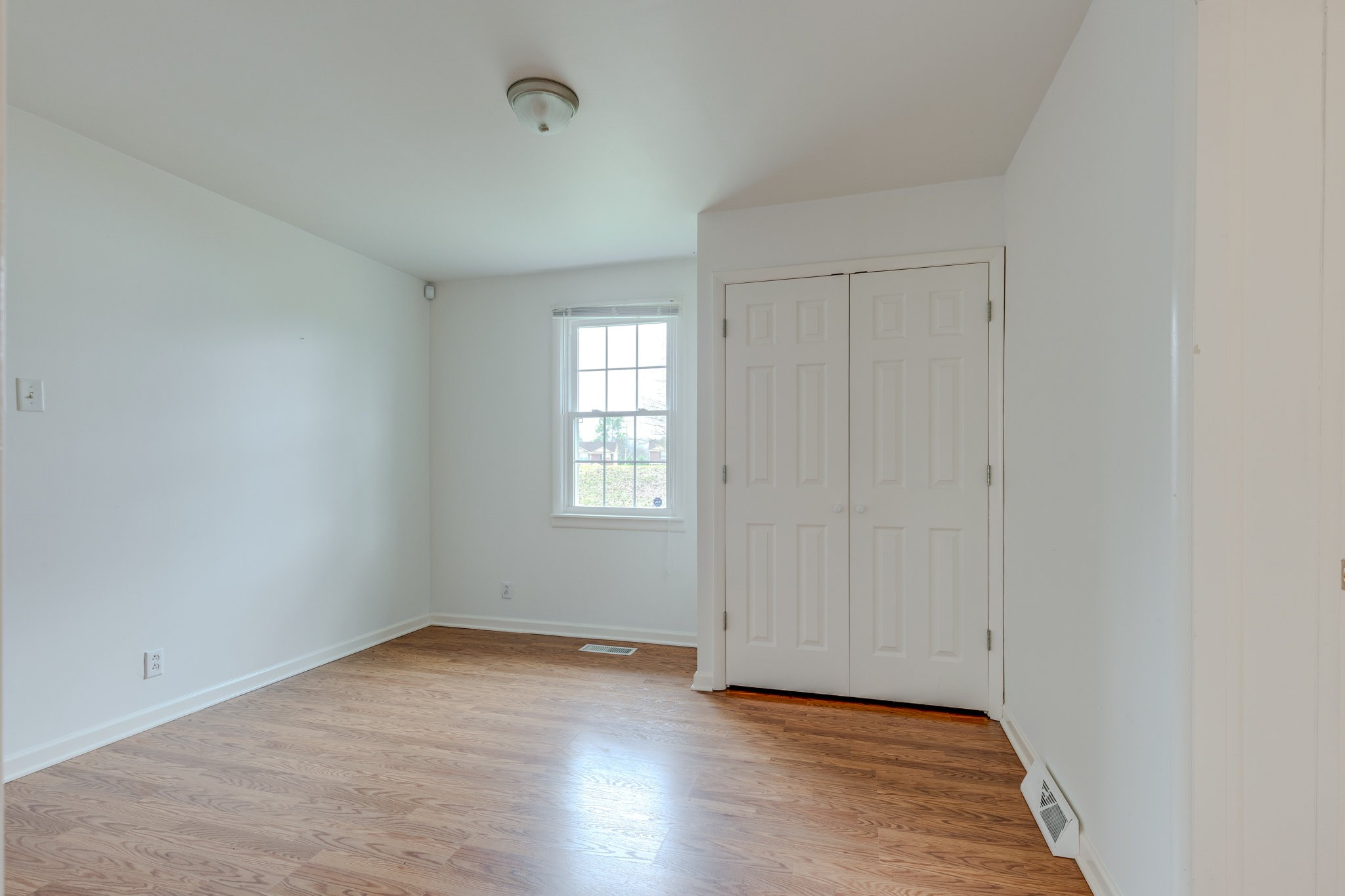 1011 Vales Mill Road Pulaski, TN 38478 - Photo 27 of 32 an empty room with wooden floor and windows