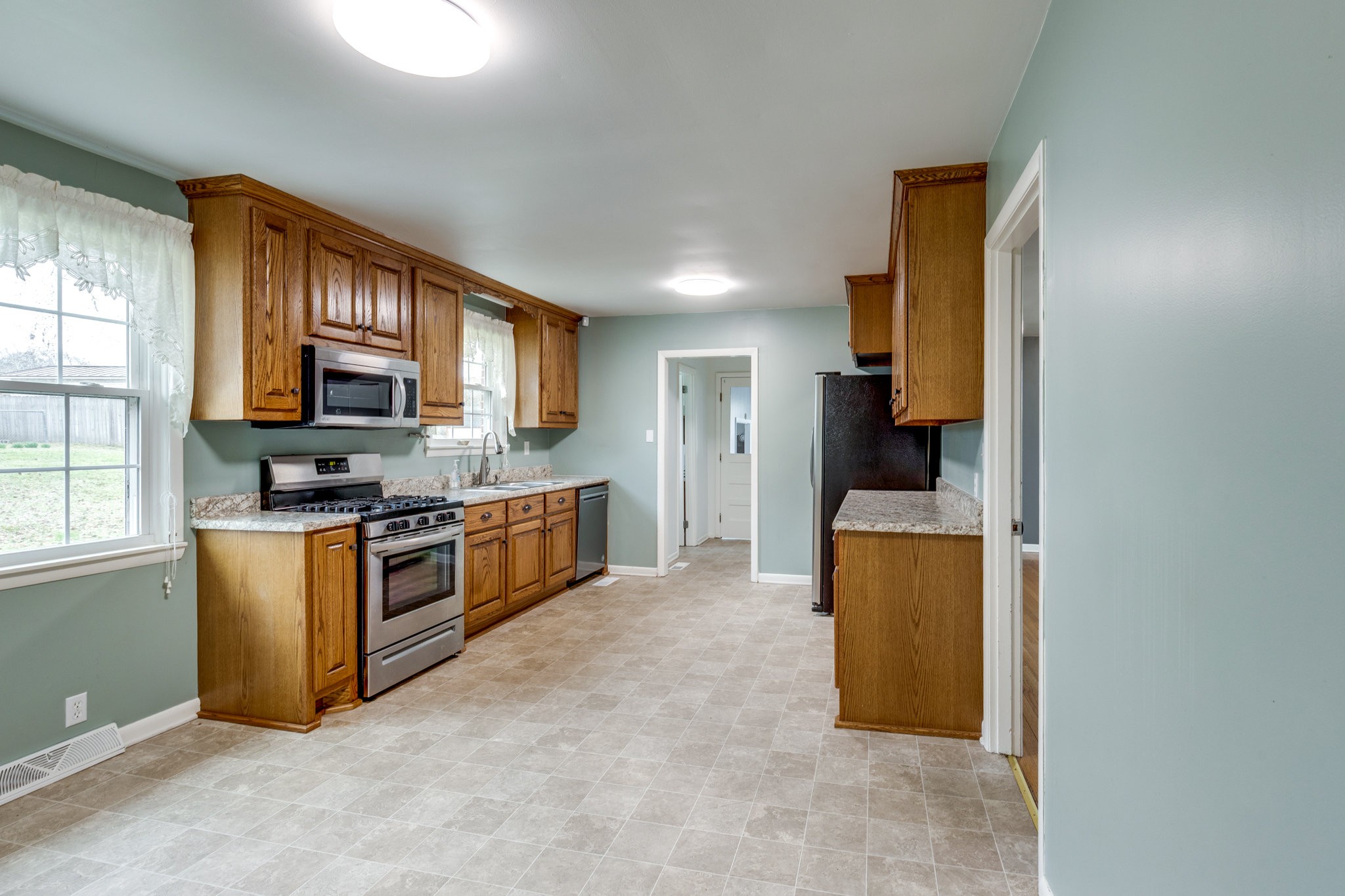 1011 Vales Mill Road Pulaski, TN 38478 - Photo 6 of 32 a kitchen with stainless steel appliances granite countertop a stove a sink a refrigerator a microwave oven with cabinets