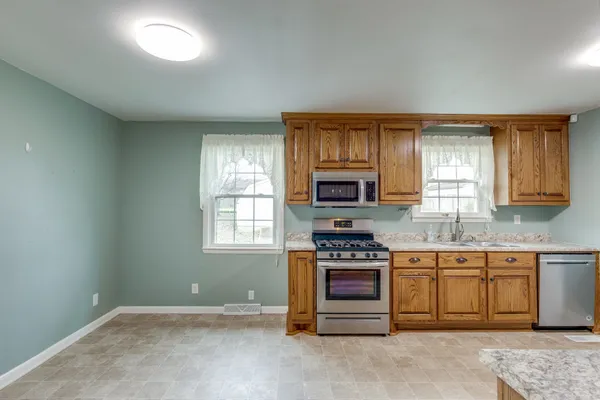 a kitchen with stainless steel appliances granite countertop a stove sink and microwave
