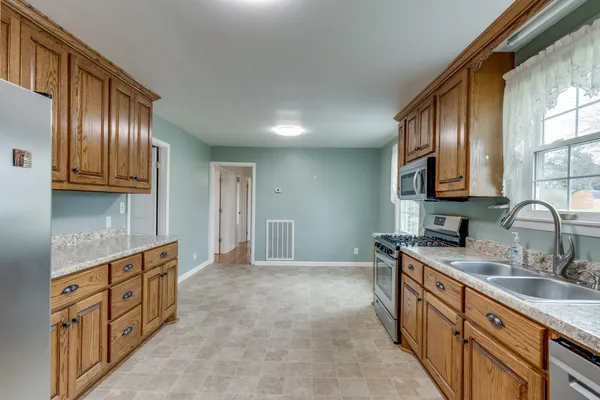 a kitchen with stainless steel appliances granite countertop a sink stove and cabinets