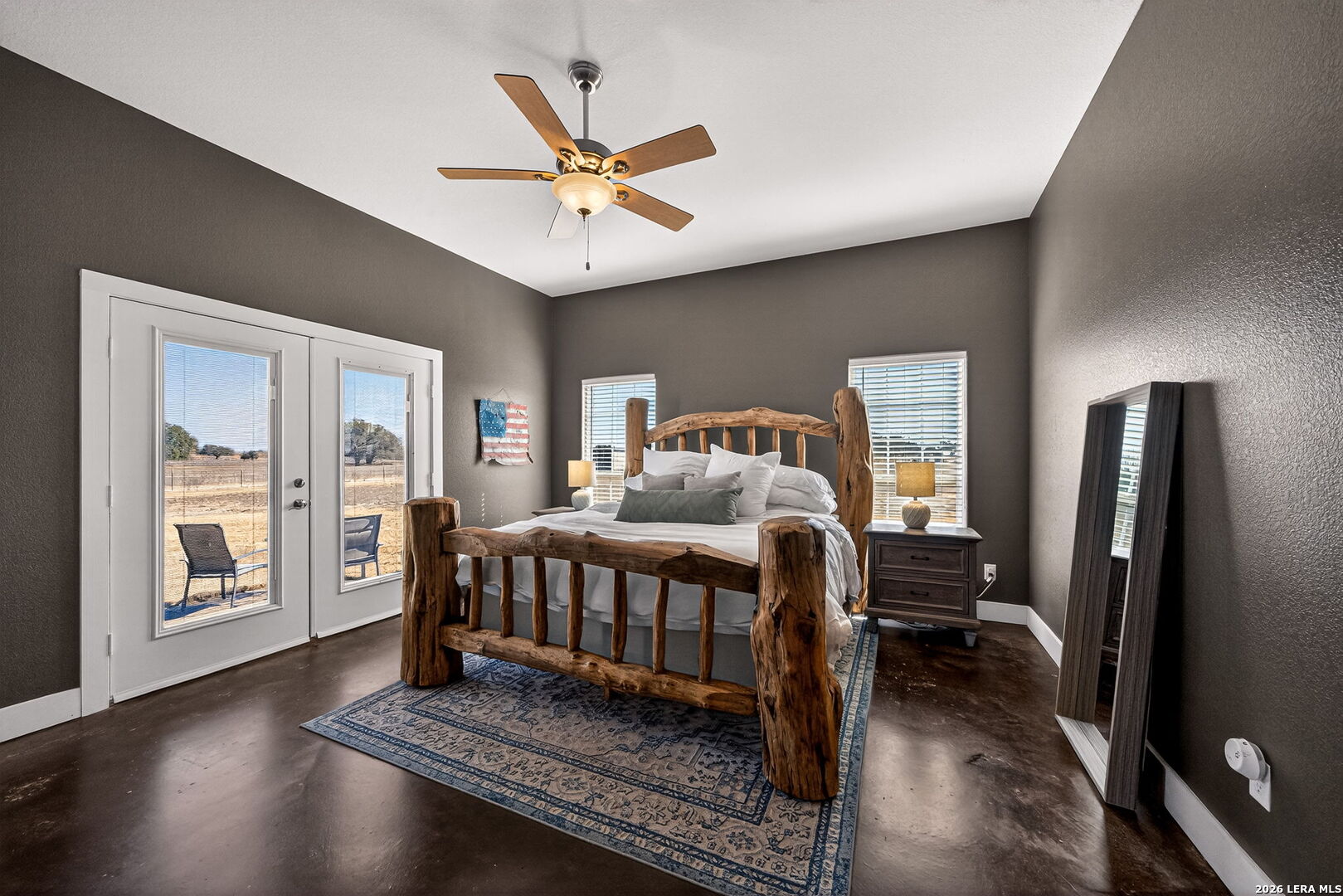 932 County Road 761 Devine, TX 78016 - Photo 22 of 47 a bedroom with a bed next to a large window with a bookshelf