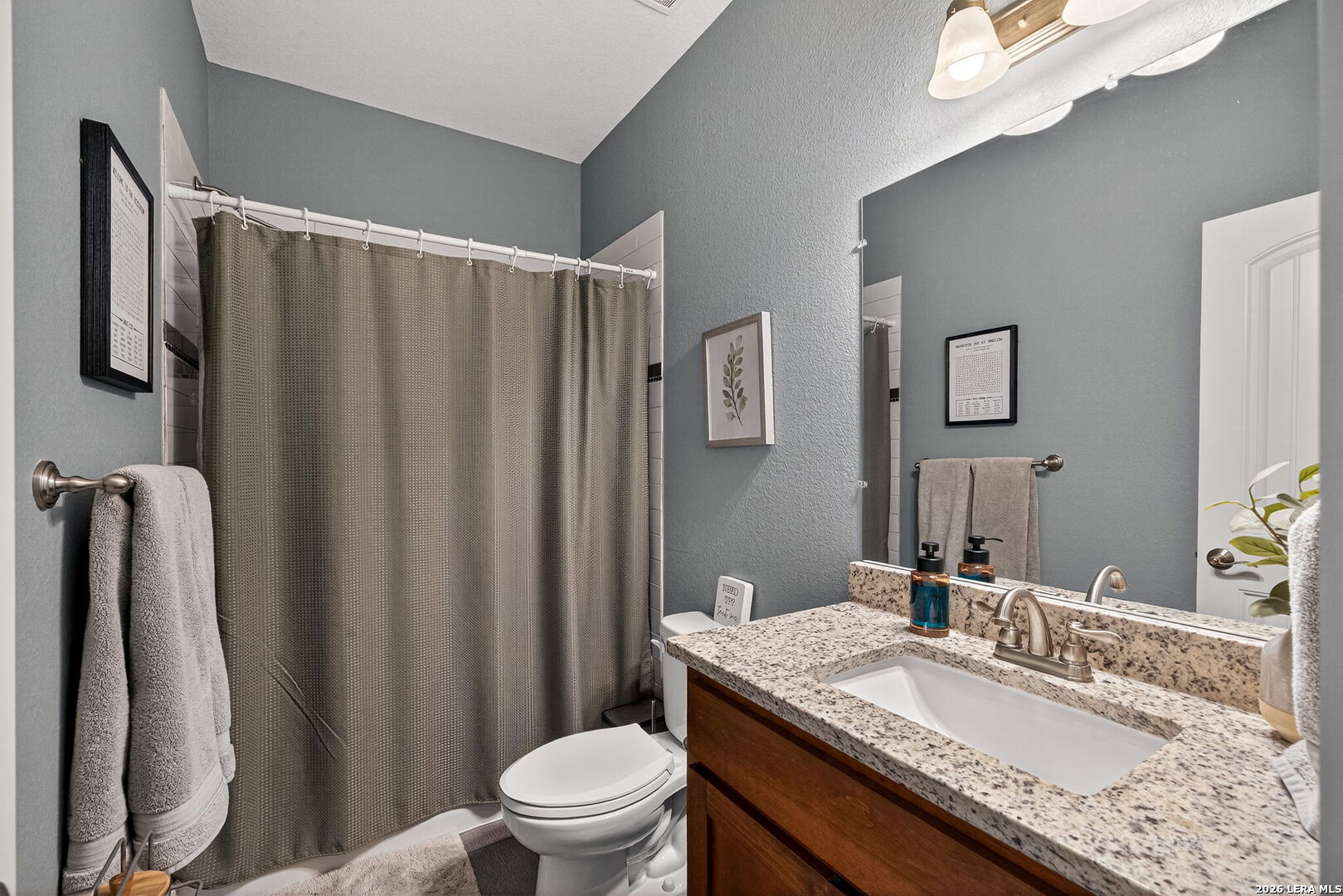 932 County Road 761 Devine, TX 78016 - Photo 28 of 47 a bathroom with a granite countertop sink toilet and a mirror