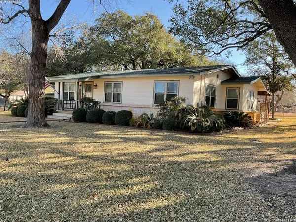 a front view of house with yard and trees around