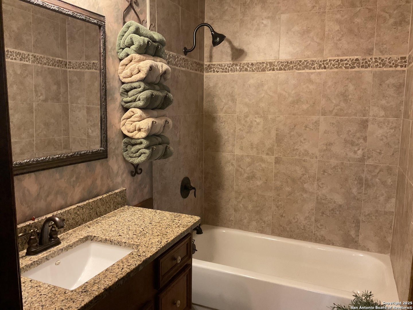 1408 Libold Drive Devine, TX 78016 - Photo 15 of 32 a bathroom with a granite countertop sink and a bathtub
