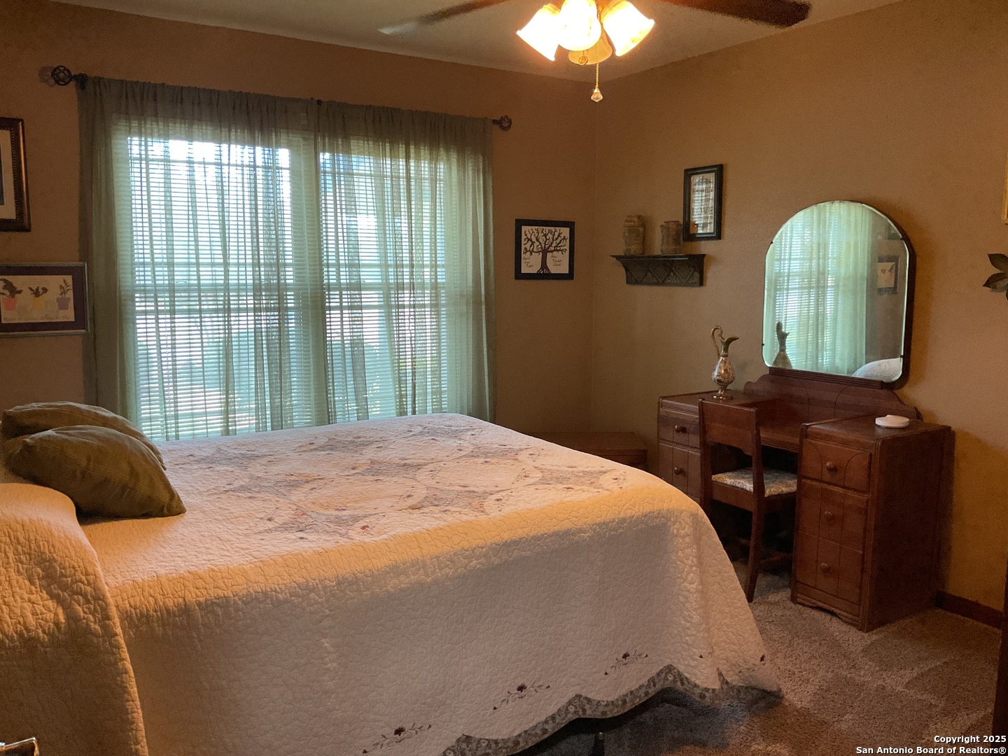 1408 Libold Drive Devine, TX 78016 - Photo 17 of 32 a bedroom with a bed and a chandelier