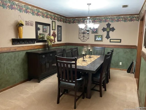 a view of a dining room with furniture and chandelier