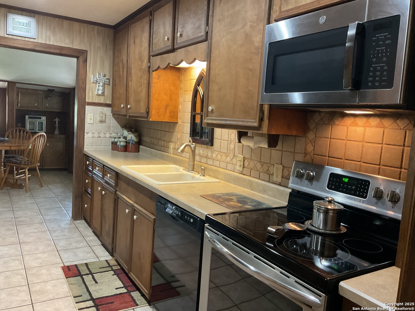1408 Libold Drive Devine, TX 78016 - Photo 5 of 32 a kitchen with stainless steel appliances granite countertop a sink stove and microwave