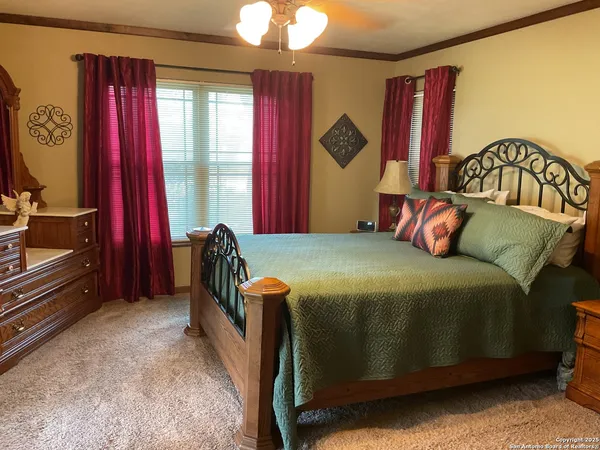 a bedroom with a bed and large windows