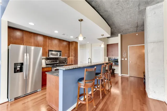 a kitchen with stainless steel appliances a refrigerator a stove microwave and cabinets