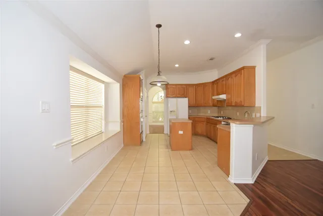 a open kitchen with stainless steel appliances kitchen island granite countertop a refrigerator a sink and a stove
