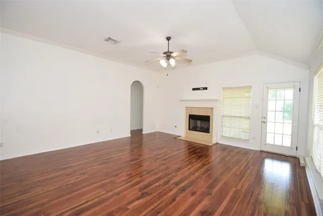 a view of an empty room with glass door and wooden floor