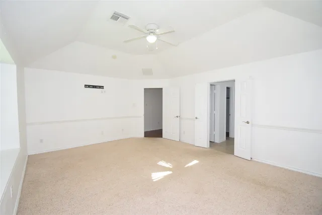 an empty room with a ceiling fan and a window