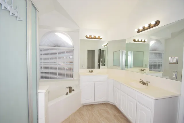 a bathroom with a tub a sink and mirror