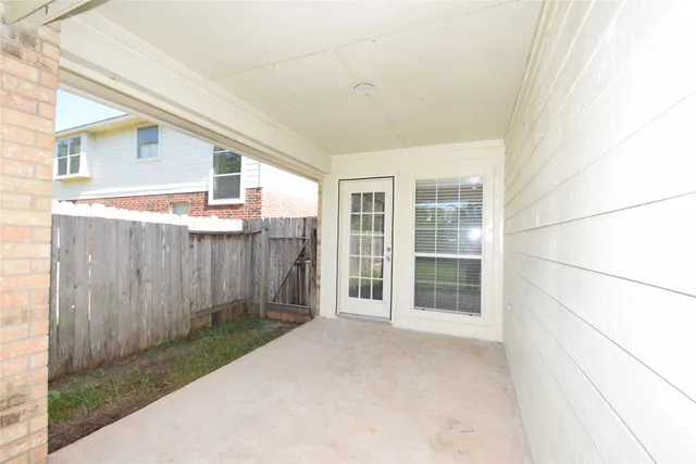 a view of a porch with wooden floor and fence