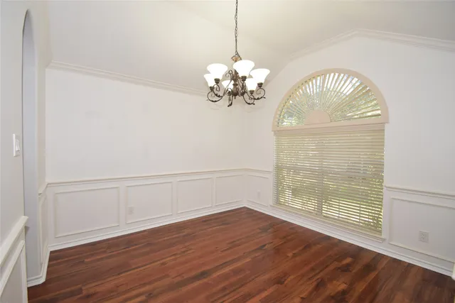 a view of a room with wooden floor and chandelier