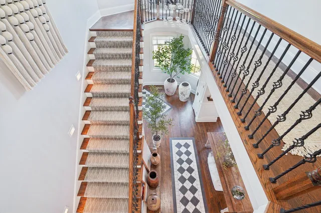 a view of a backyard with table and chairs potted plants and large tree