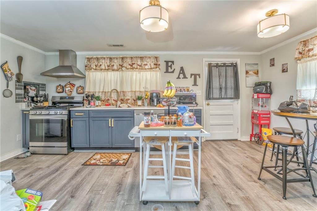 424 Wayside Road Rome, GA 30161 - Photo 4 of 16 a kitchen with stainless steel appliances granite countertop a stove top oven a dining table and chairs with wooden floor