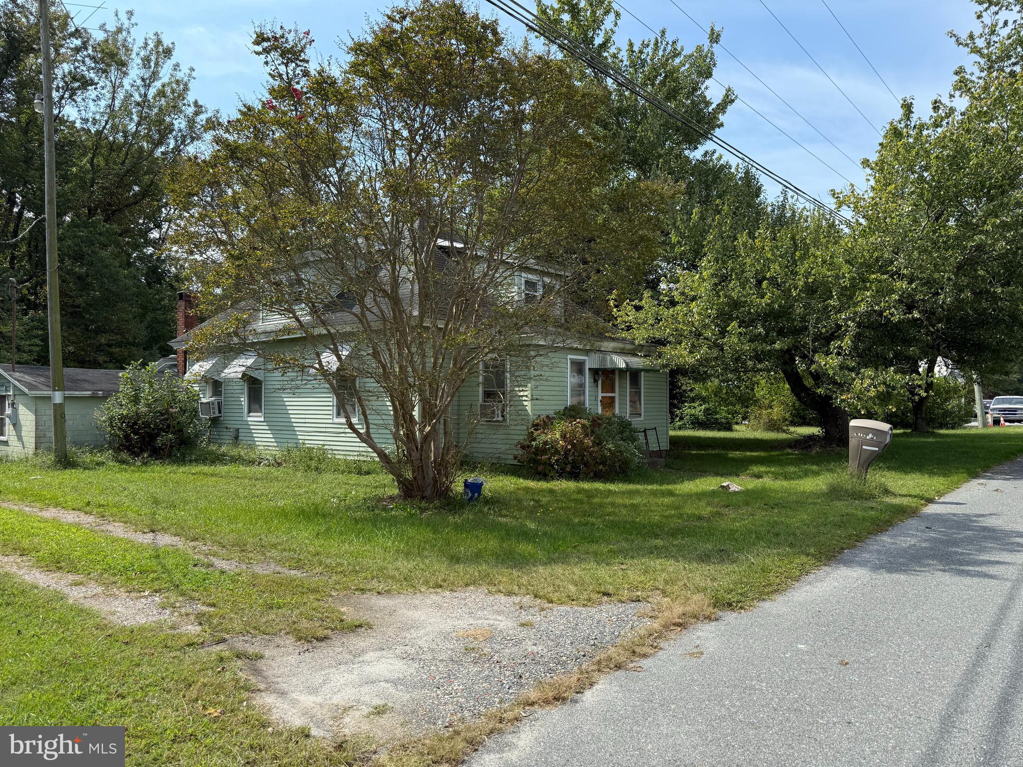 a view of a big house with a big yard and large trees