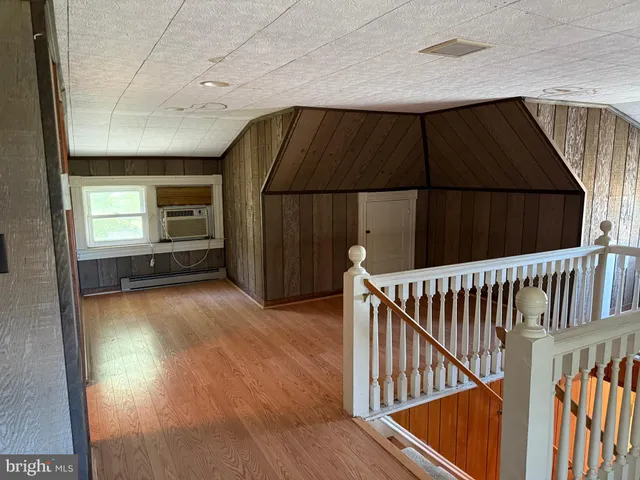 a view of a hallway with wooden floor and stairs