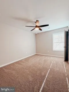 an empty room with a ceiling fan and window