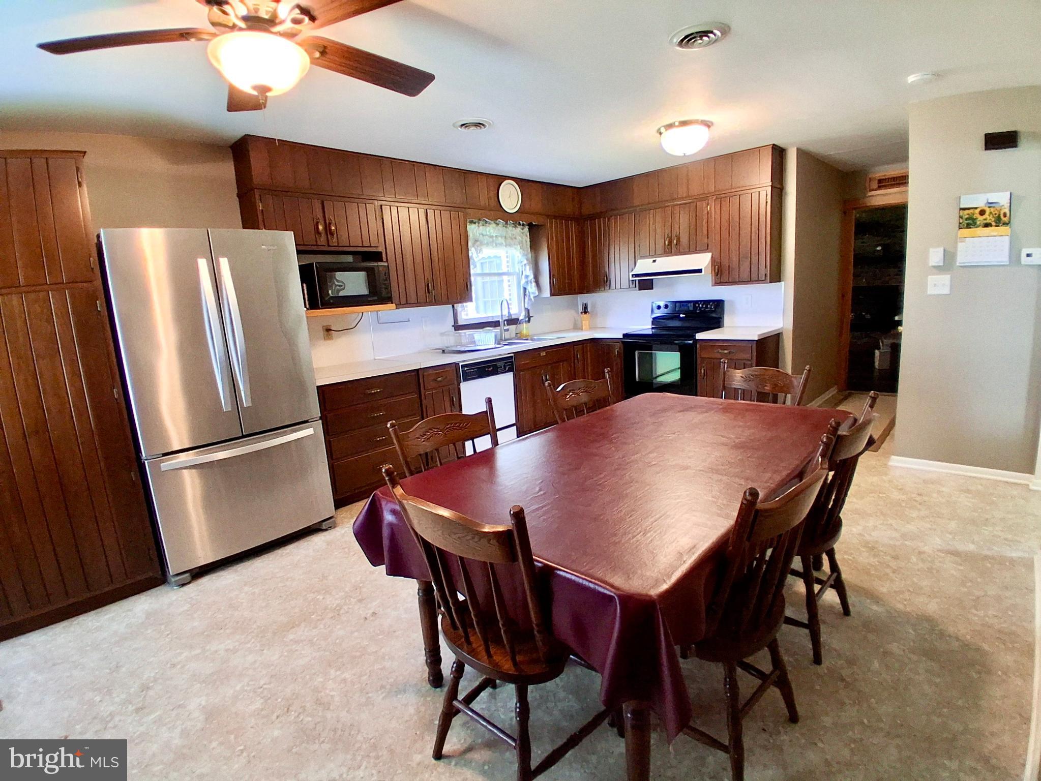 9 Buch Mill Road Lititz, PA 17543 - Photo 37 of 39 a kitchen with stainless steel appliances a table chairs refrigerator and microwave