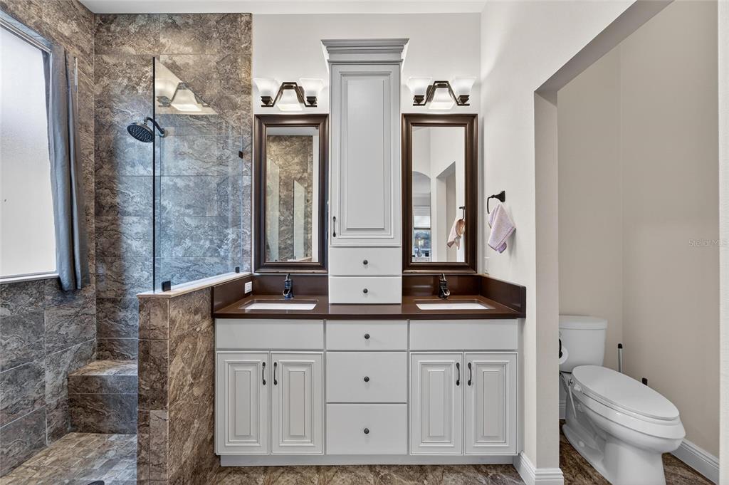 3522 Fox Squirrel Lane Valrico, FL 33596 - Photo 44 of 82 a bathroom with a granite countertop sink a toilet and a mirror