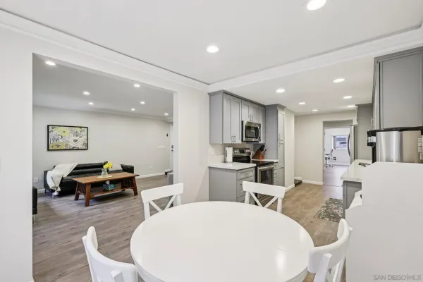 a living room with furniture a table and kitchen view