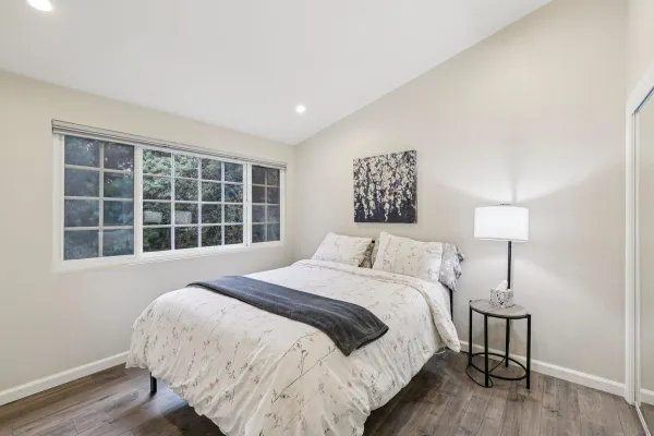 a spacious bedroom with a bed and a window