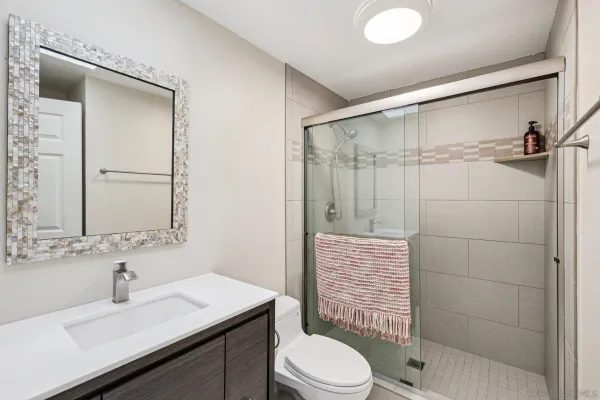 a bathroom with a sink a toilet and shower