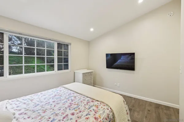 a bedroom with a bed and a flat screen tv