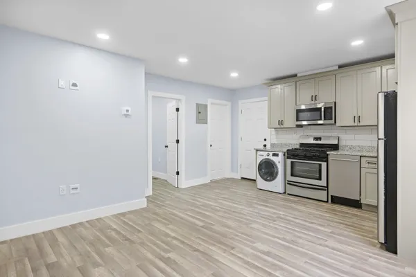 a kitchen with granite countertop a refrigerator and a stove top oven
