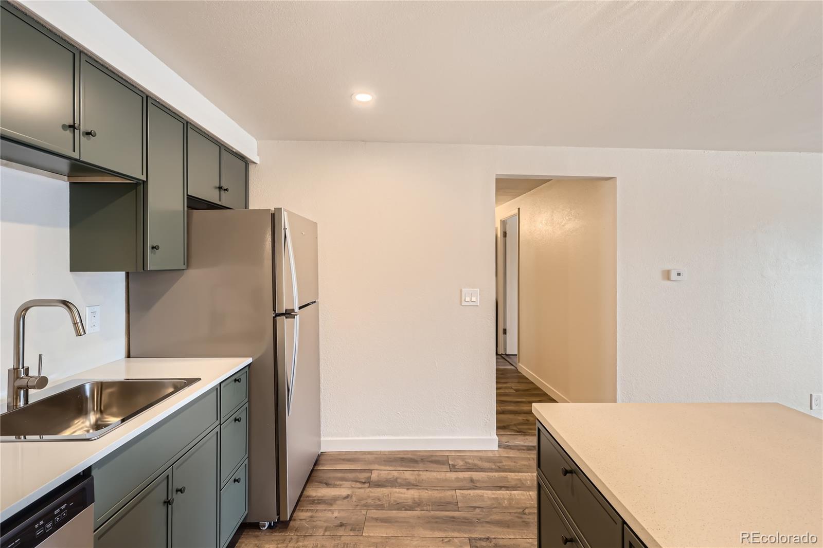 1302 South Parker Road, Unit 229 Denver, CO 80231 - Photo 3 of 18 a kitchen with stainless steel appliances a refrigerator and a sink